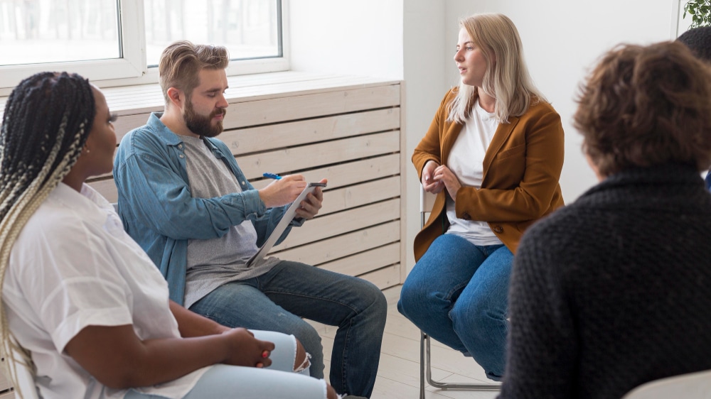 Man taking notes during group therapy in Nashville counseling session