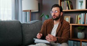 Male therapist taking notes during an individual counseling session at a men's addiction treatment center in Nashville Wellness.