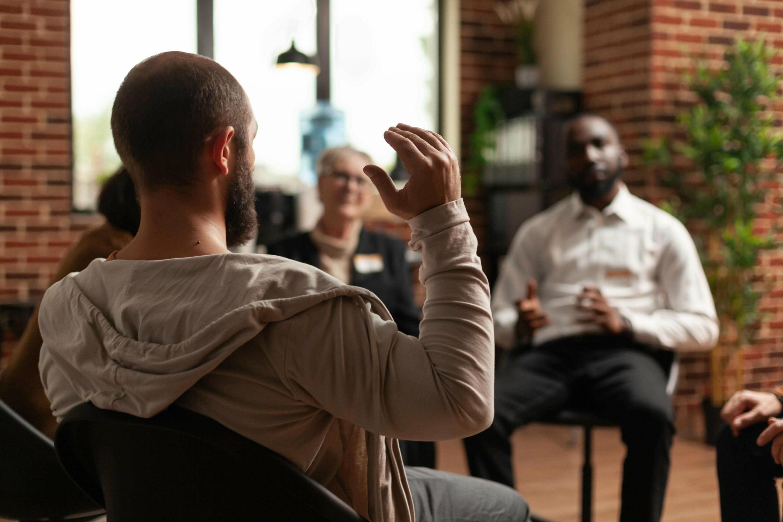 Man sharing his recovery journey during group therapy at a rehab for men in Nashville through Nashville Wellness.
