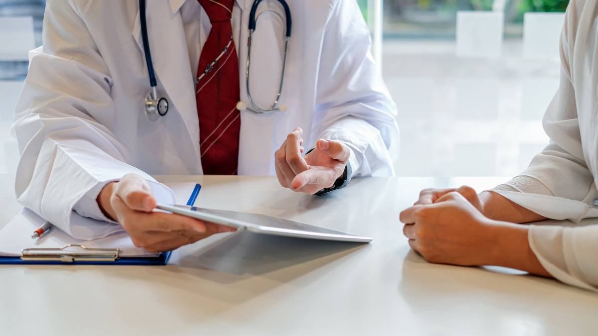 Doctor showing an insurance plan on a tablet to a patient for Aetna rehab in Nashville, TN.
